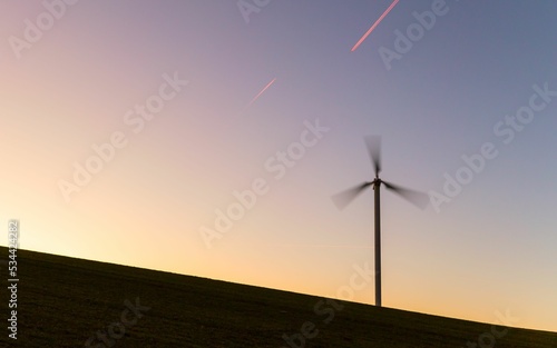 Beautiful sunset with a winmill in movement photo