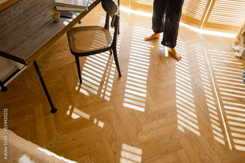 Schilderij op canvas View from above on wooden floor made of parquet laid with herringbone and woman walks on it