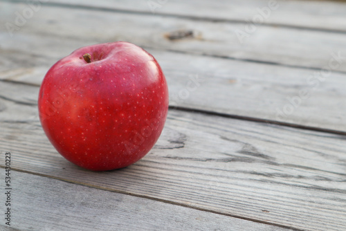 Red ripe apple on a rustic gray wooden boards. Copy space