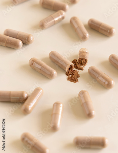 Opened Medical capsules on light beige close up. Taking dietary supplements