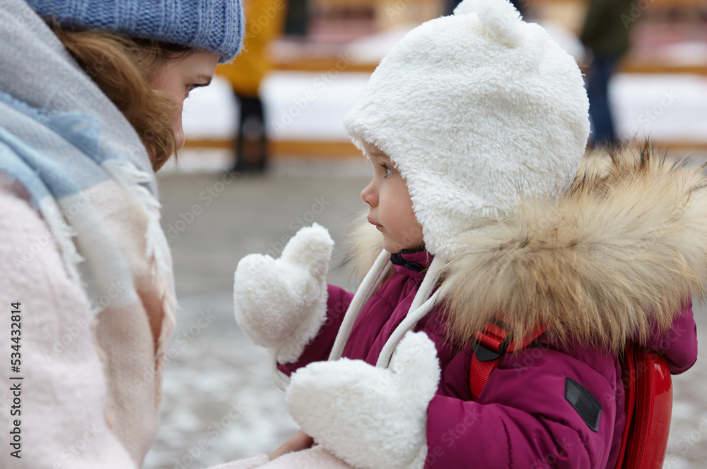 Mother and daughter are walking around the city on Christmas and New Year holidays. Parent and little child having fun outdoors Mother and daughter are walking around the city on Christmas and New Year holidays. Parent and little child having fun outdoors