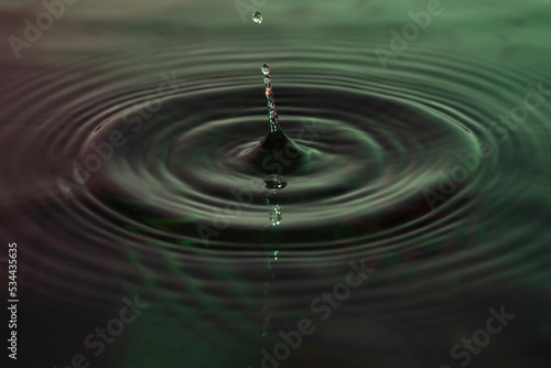 Green and red water dropping, water ripples in a pond. waves of rippling water.