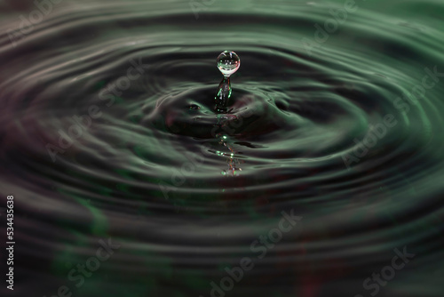 Green and red water dropping, water ripples in a pond. waves of rippling water.