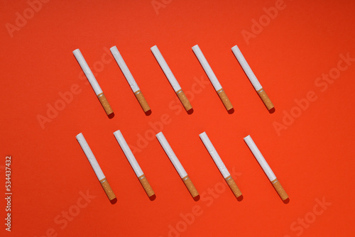 Concept of harm of smoking, cigarettes on orange background