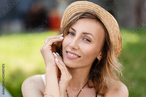 Woman smiling with perfect smile and white teeth in a park and looking at camera.
