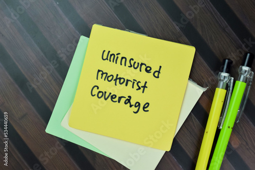 Slika na platnu Concept of Uninsured Motorist Coverage write on sticky notes isolated on Wooden Table