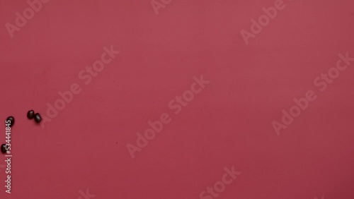 Text Coffee made from Roasted Coffee beans blowing out on pink top view