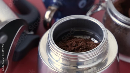 The process of making coffee in Italian moka pot – ground coffee put inside a moka pot close up photo