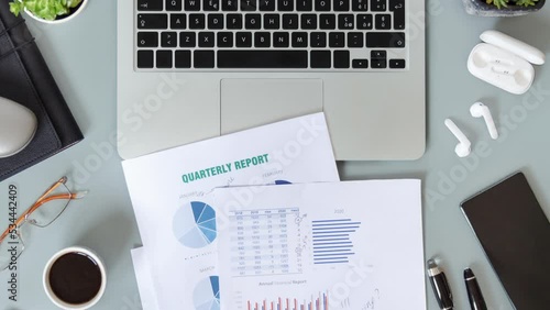 Modern office desktop with laptop, succulent plants, documents and gadget’s top view. Working on quarterly reports with coffee cup. Smark working at home. Stopmotion