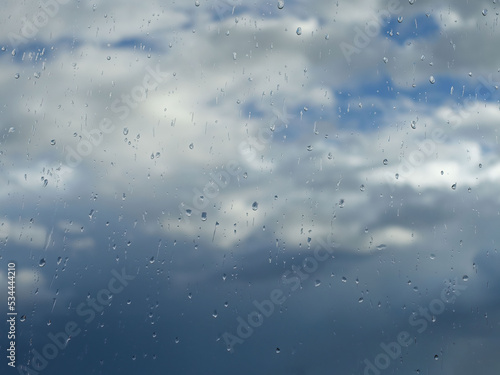Rain drops on the window with clouds and sky background after the rain