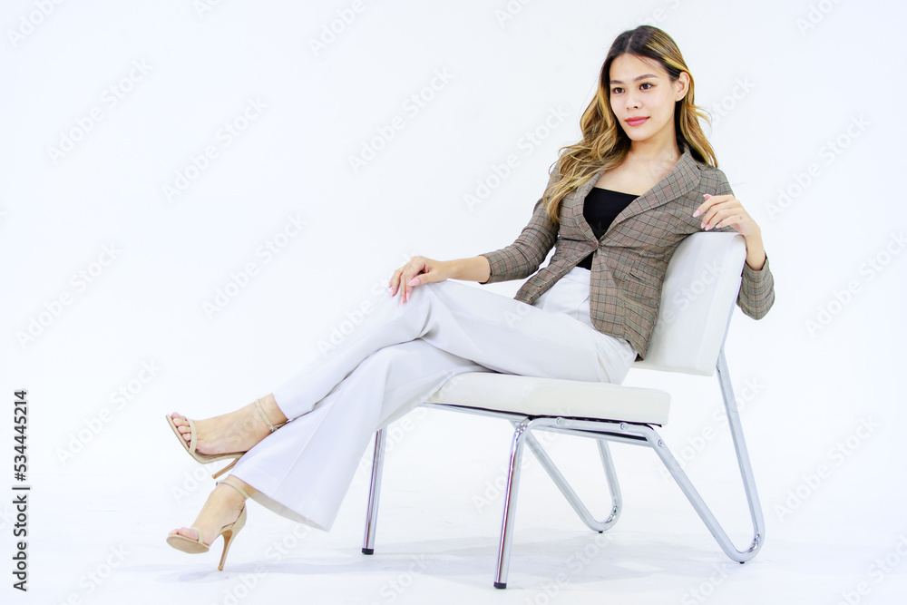 Portrait isolated cutout full body studio shot Millennial Asian successful professional female businesswoman in casual business suit sitting on chair smiling look at camera posing on white background. Portrait isolated cutout full body studio shot Millennial Asian successful professional female businesswoman in casual business suit sitting on chair smiling look at camera posing on white background.