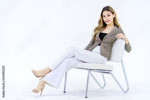 Portrait isolated cutout full body studio shot Millennial Asian successful professional female businesswoman in casual business suit sitting on chair smiling look at camera posing on white background. © Bangkok Click Studio
