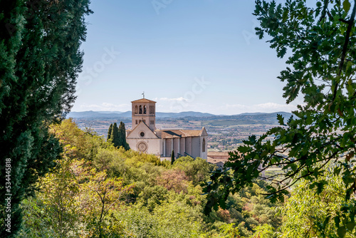 View of the ancient Basilica of San Francesco, Assisi, Perugia, Italy, framed by tree branches