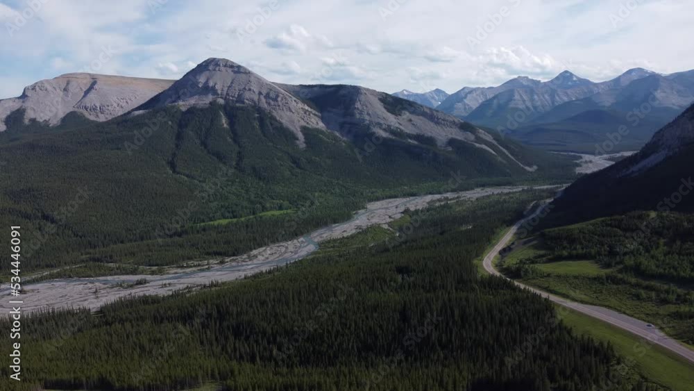 High mountains with road and mountain river covered with forest High mountains with road and mountain river covered with forest