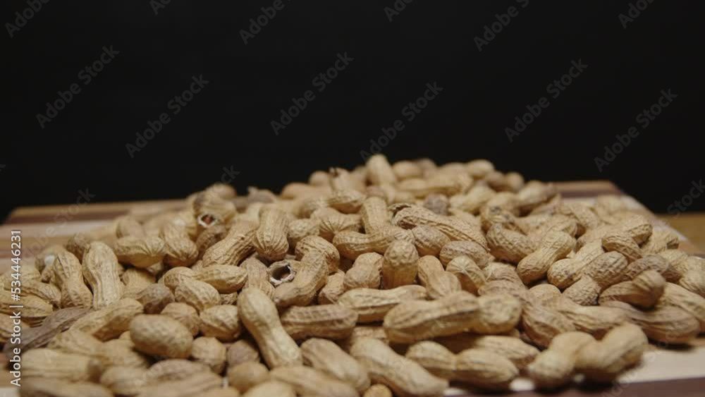 Spinning pile of peanuts on cutting board, wide angle on a cutting board. Spinning pile of peanuts on cutting board, wide angle on a cutting board.