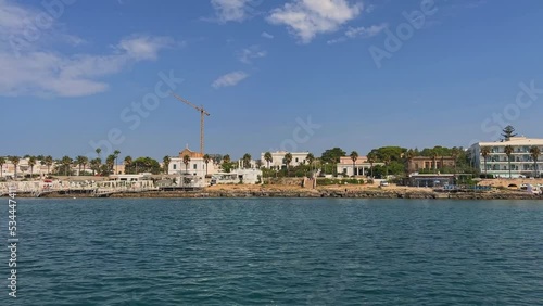 Coastline of Santa Maria di Leuca south Italian town seen from sailing boat moving along Ionian coast of Salento in Apulia, Italy. Low angle water surface pov photo