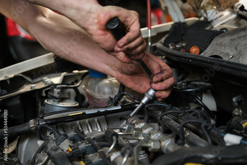 Close up of car mechanic hands doing car service and maintenance. Mechanics workshop. © Ladanifer