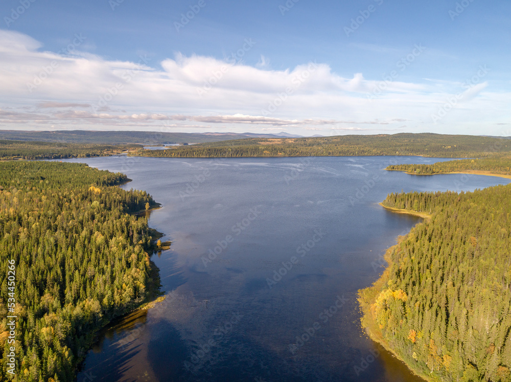 Aerial view famous waterfall Tannforsen northern Sweden, with a rainbow in the mist and rapid flowing cascades of water