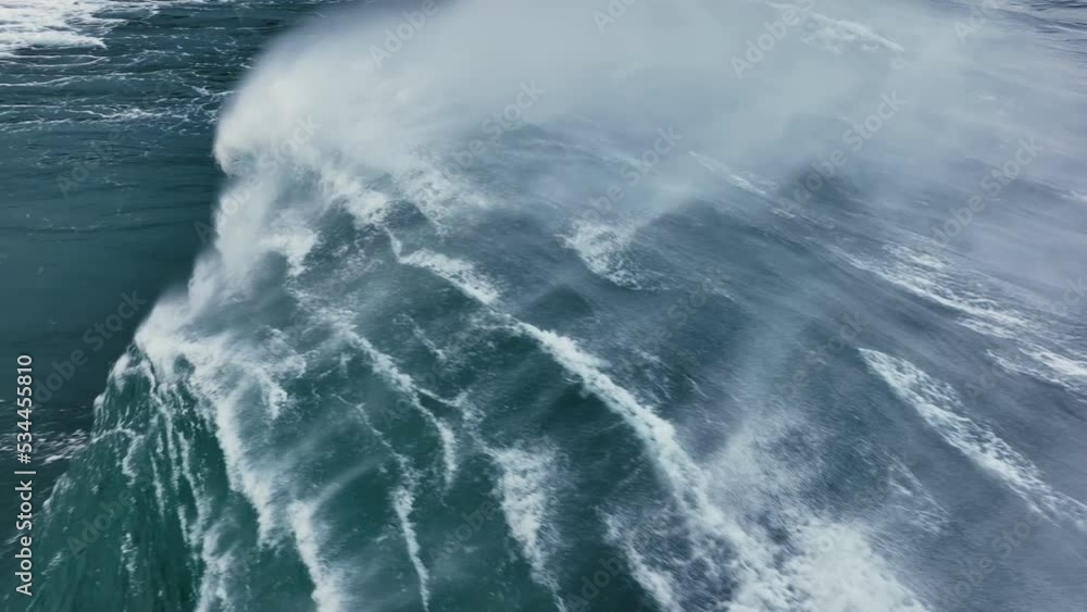 Slow motion aerial shot of powerful wave crashing. Sea or ocean big stormy surf clear turquoise water with foamy white texture. Stormy powerful waves in open Atlantic ocean Slow motion aerial shot of powerful wave crashing. Sea or ocean big stormy surf clear turquoise water with foamy white texture. Stormy powerful waves in open Atlantic ocean