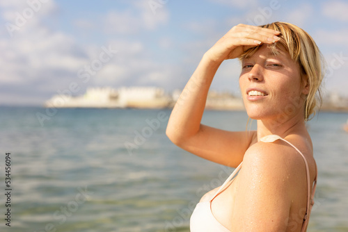 Beautiful woman swimming in the ocean. Smiling blonde girl enjoy in sunny day