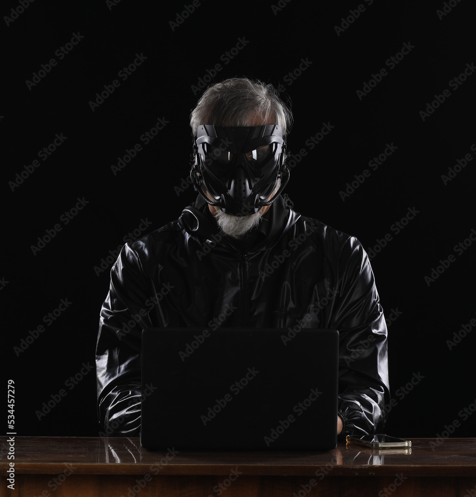 masked hacker with laptop at night masked hacker with laptop at night
