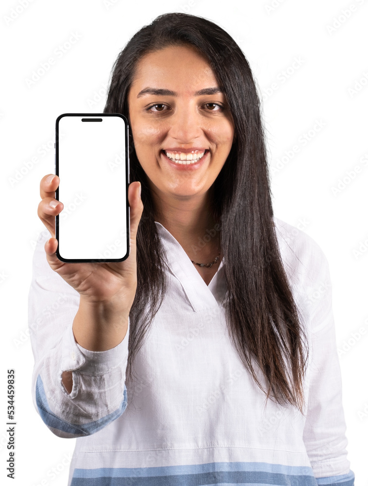 Holding modern phone, showing white blank screen of smartphone to camera while holding modern phone. Portrait of young smiling happy woman standing isolated white background. Caucasian female model.