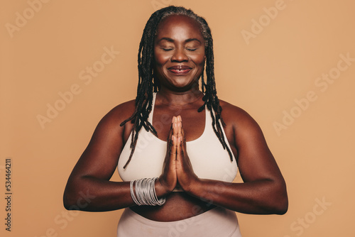 фотографія Mature woman meditating in a studio