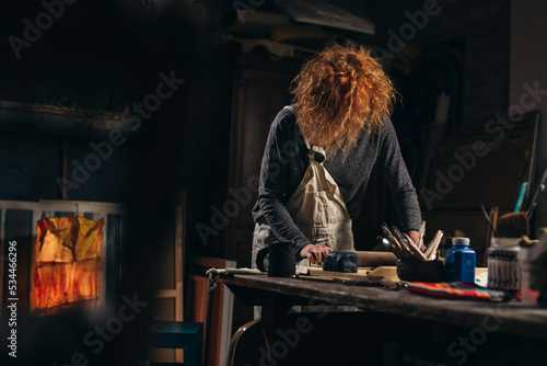 mid adult woman craftsman working with pottery in her work shop