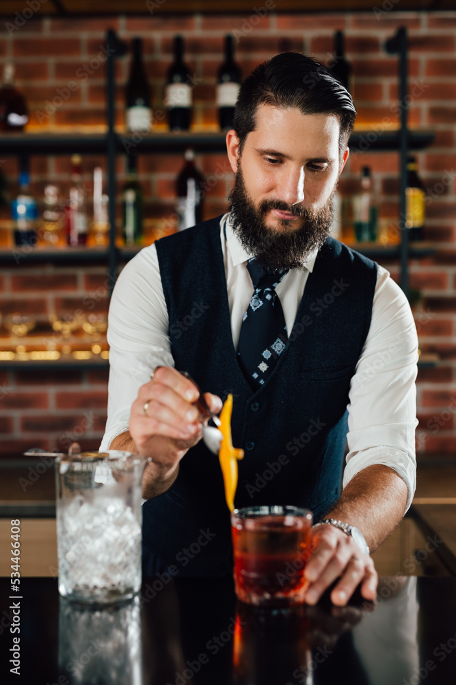 caucasian barman decorating cocktail in bar