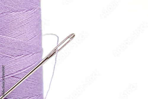 Macro skein of thread purple colors with a needle on a white background © Minakryn Ruslan 