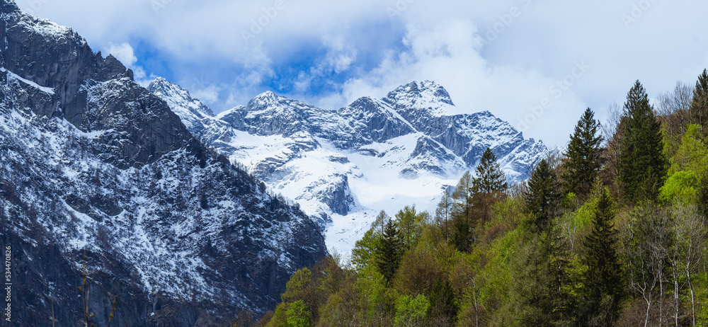 the mountains of val masino and val di mello with fresh snow, during a sunny day, near the town of San Martino, Italy - April 2022. the mountains of val masino and val di mello with fresh snow, during a sunny day, near the town of San Martino, Italy - April 2022.