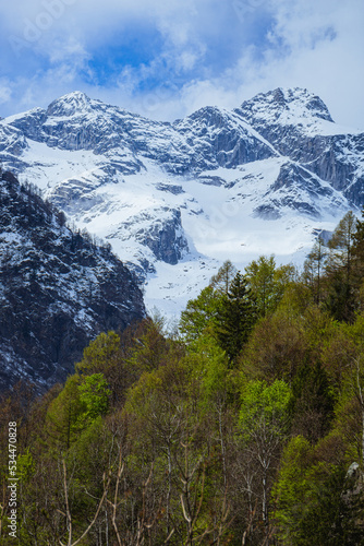 the mountains of val masino and val di mello with fresh snow  during a sunny day  near the town of San Martino  Italy - April 2022.