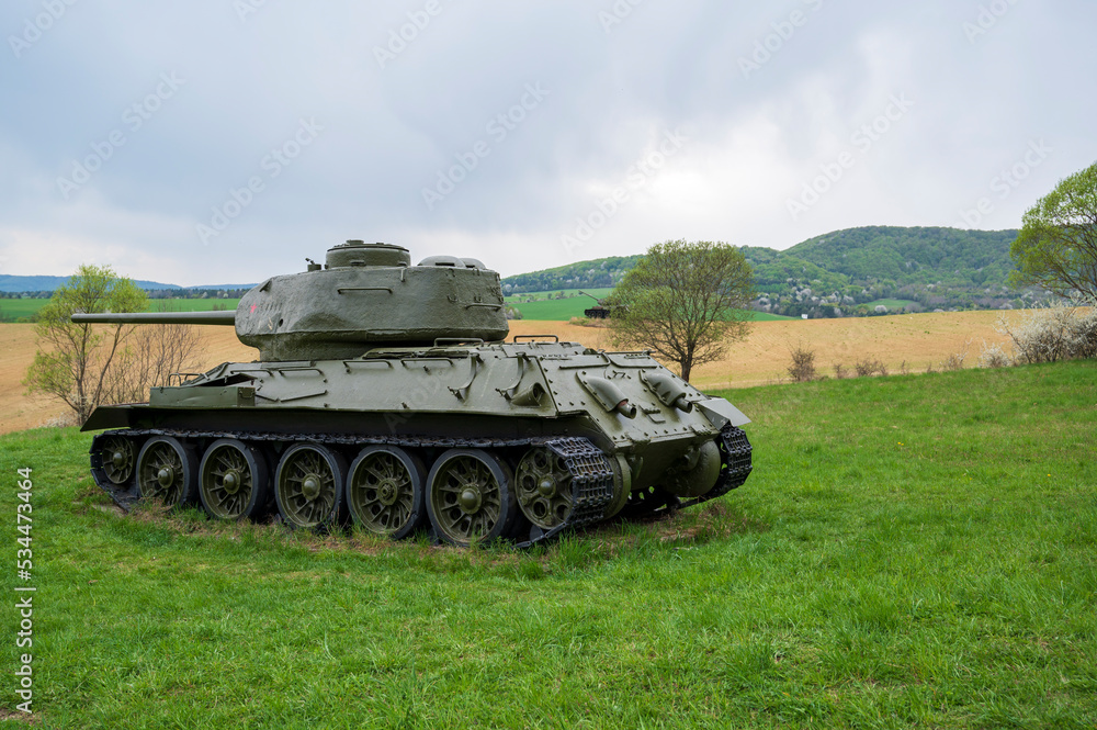 Old Soviet tank is parked on green meadow. Old Soviet tank is parked on green meadow.