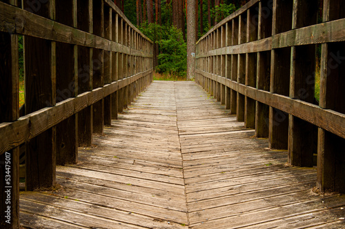 wooden bridge over the river with a signpost