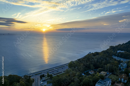 The sun rises over Gdansk Bay in Gdynia from the side of the city boulevard, aerial photo