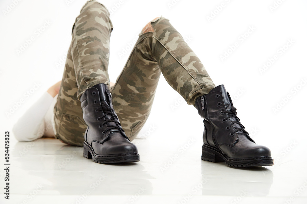Female winter, autumn or spring black leather shoes on leg of woman in studio on white background. Fashionable modern photography and photoshoot for a store, catalog, magazine or online Female winter, autumn or spring black leather shoes on leg of woman in studio on white background. Fashionable modern photography and photoshoot for a store, catalog, magazine or online