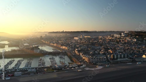 Aerial drone view of the coastal cliffs and city of Fécamp at sunrise in Normandy - France. Harbor city with chalk cliffs photo