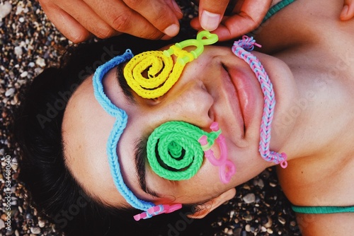 closeup of smiling young woman with child game on face at summer day