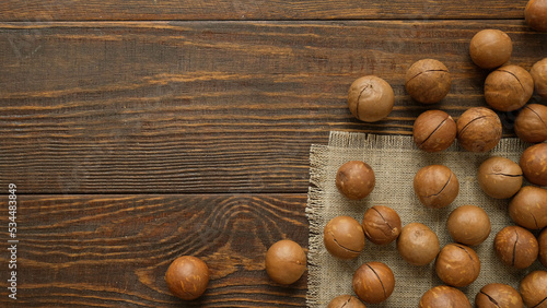 Macadamia nuts a fabric napkin and a wooden brown background