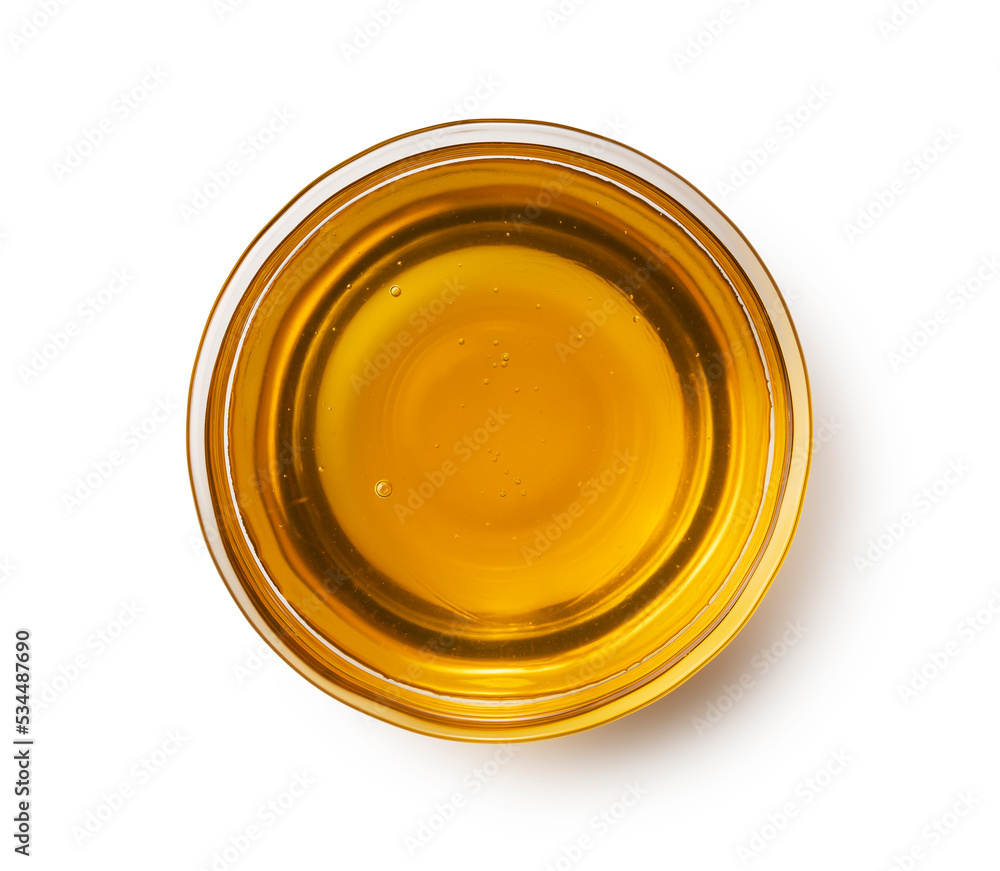 Honey in a glass container on a white background. Honey in a glass container on a white background.