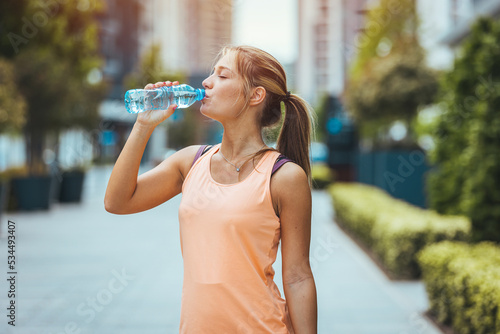 Wallpaper Mural Photo of young Woman drinking water from bottle