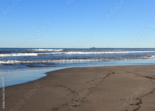 Waves at sea during storm and wind. Wave from the sea goes on land to the beach. Splashing Waves in ocean, background, texture. Wave at Rising Storm. Waves at sea during storm and wind.