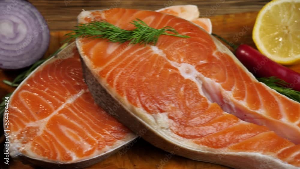 Raw fresh salmon steaks on a wooden cutting board. On a wooden background Raw fresh salmon steaks on a wooden cutting board. On a wooden background