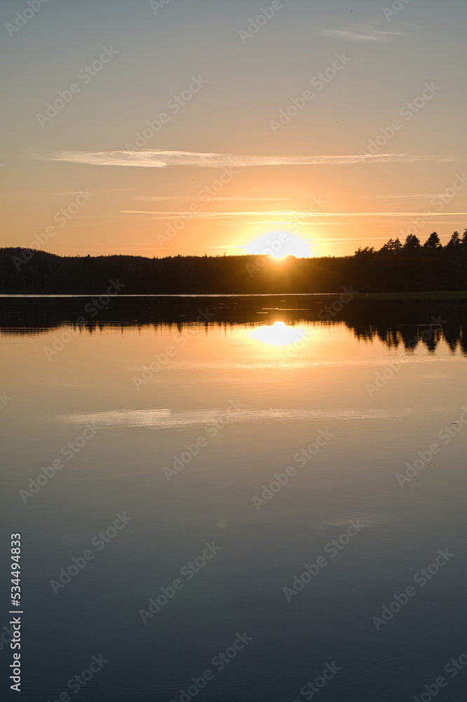Sunset with reflection on a Swedish lake in Smalland. Romantic evening mood