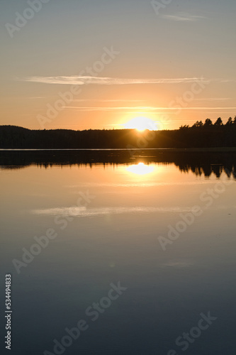 Sunset with reflection on a Swedish lake in Smalland. Romantic evening mood