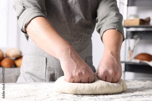 Man kneading dough at table in kitchen, closeup © New Africa