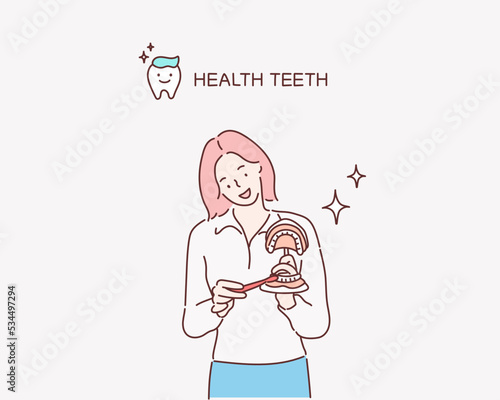 
Dentist showing on a jaw model how to clean the teeth with tooth brush properly and right. Hand drawn style vector design illustrations.