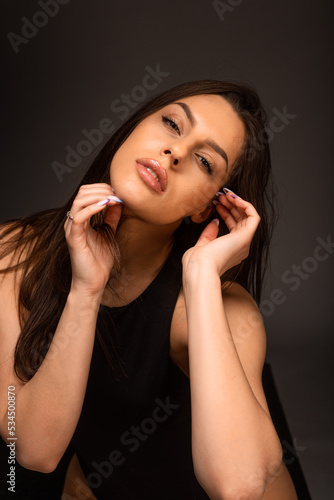 Portrait of young beautiful girl with long hair posing in studio