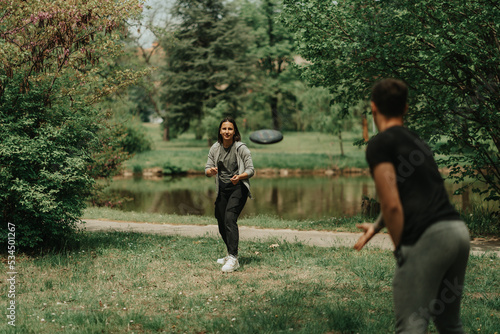 Couple playing frisbee in the park