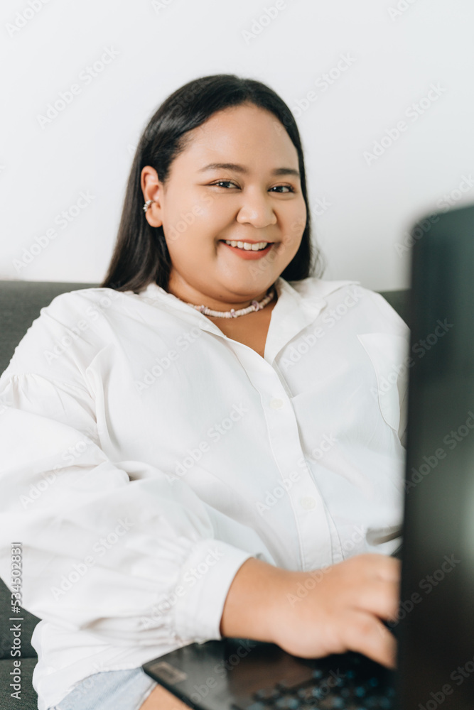 Portrait of a freelancer sitting on the couch and using laptop at home